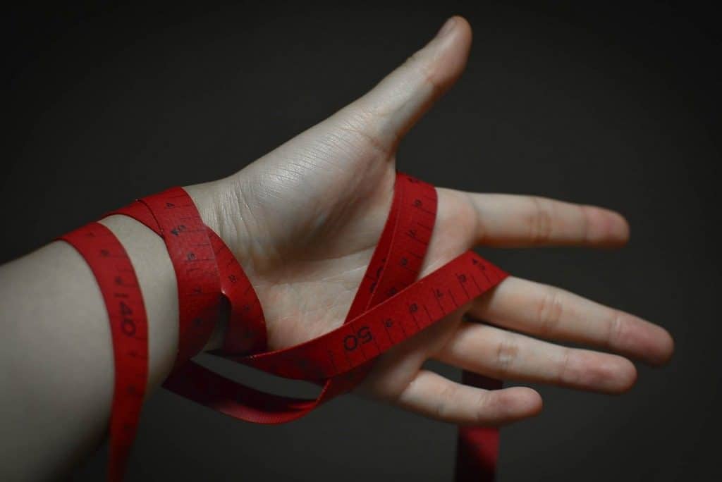 hand with tape measure wound around it
