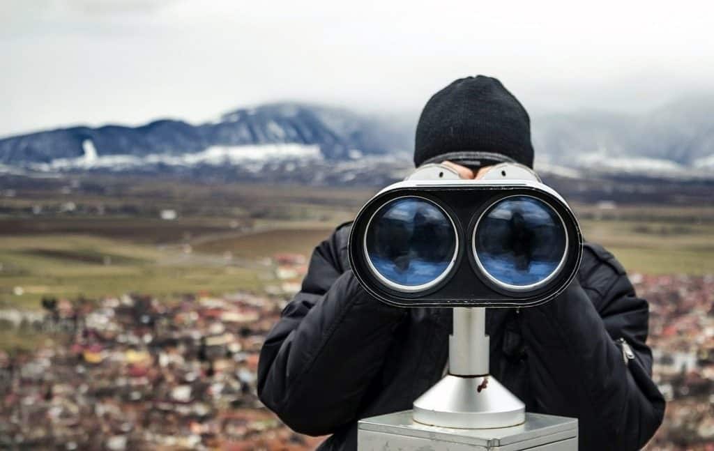 man looking through binoculars