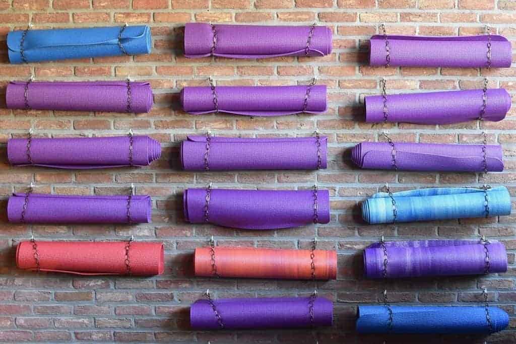 rolled yoga mats on a wall