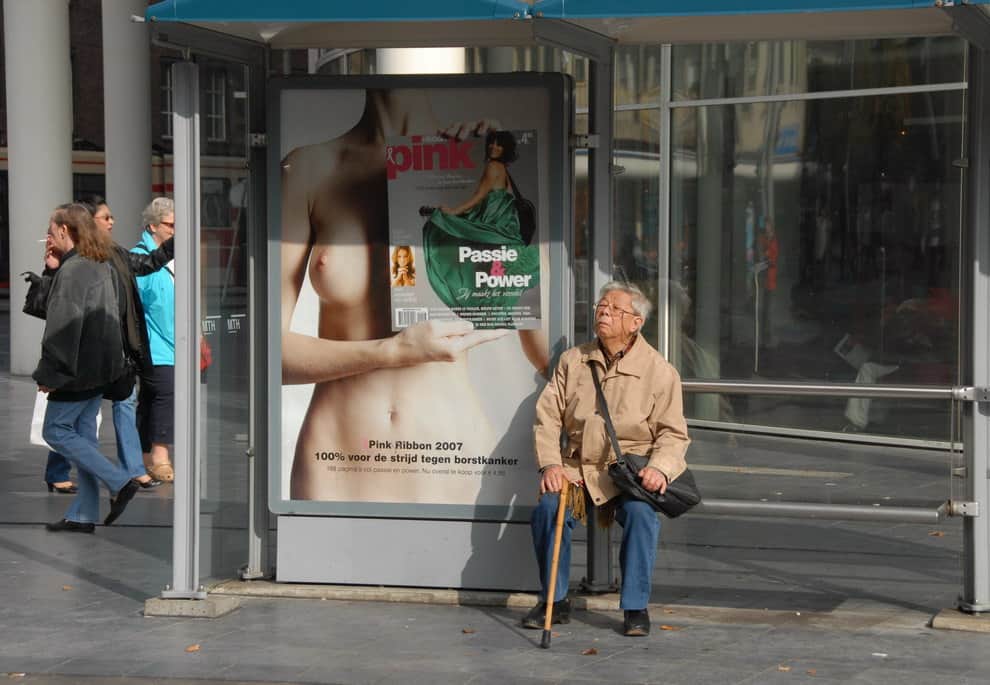 senior in front of an ad with a young woman
