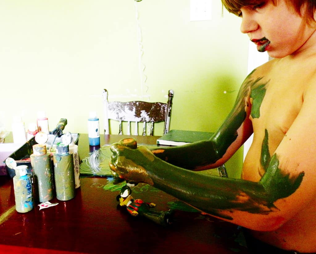 young boy covering himself in paint