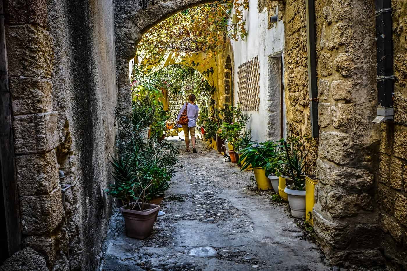 Woman walking alone on cobblestone path - The solo traveler's handbook