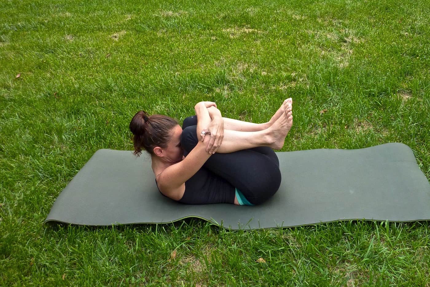 Woman doing Yoga on mat, on grass - Rise and shine