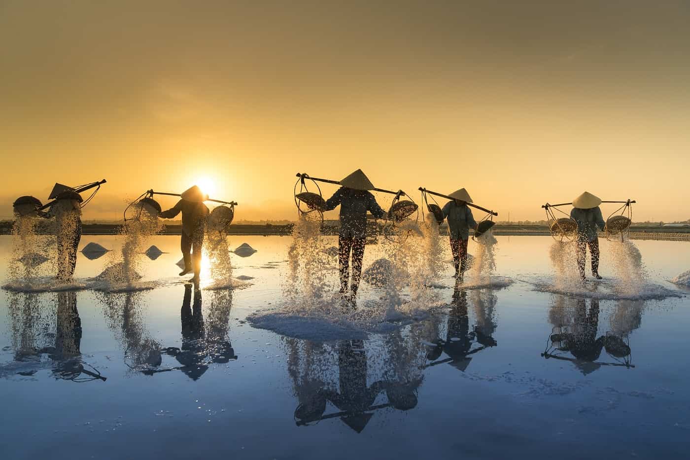 A few people harvesting salt from water