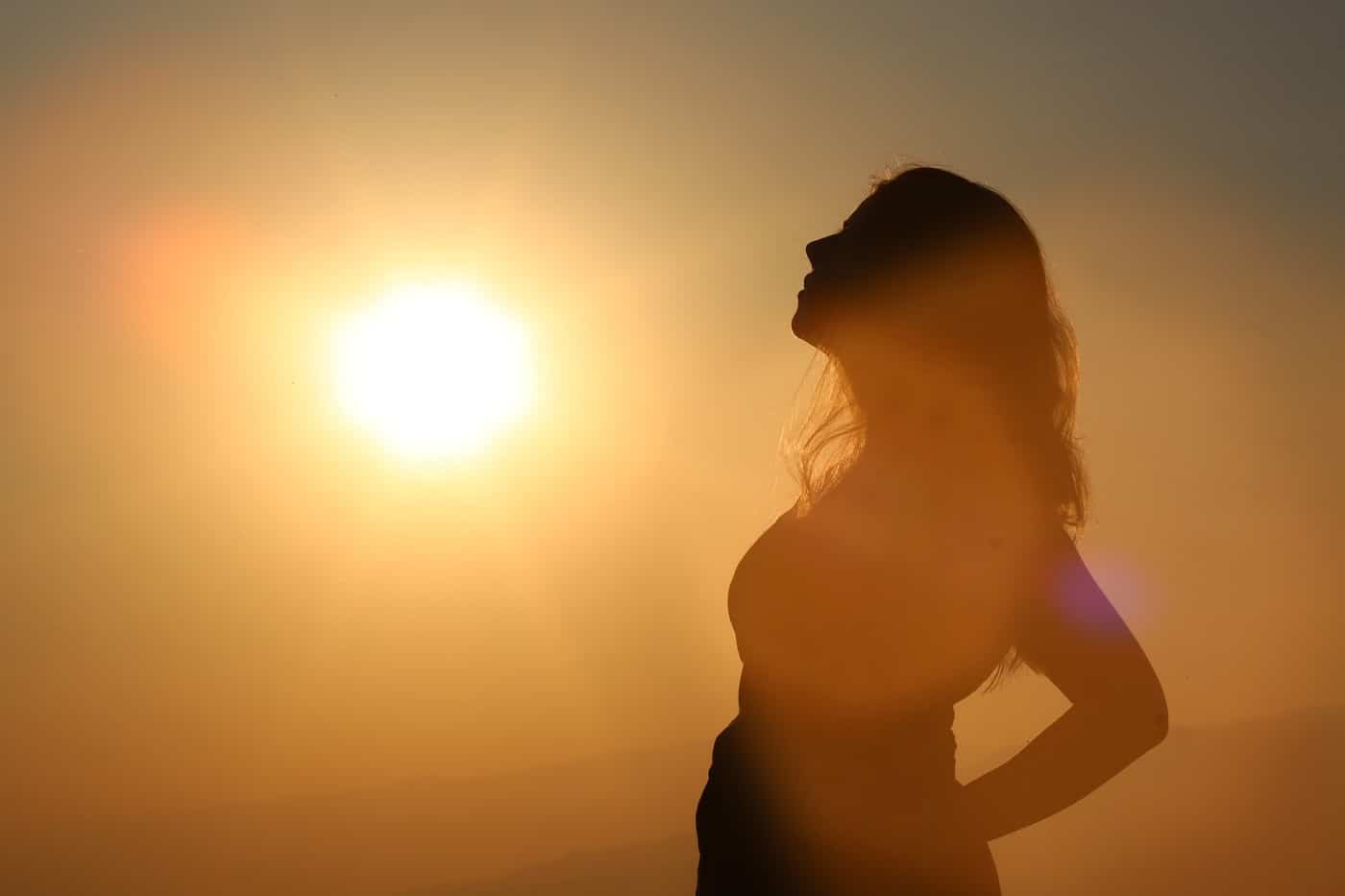 Woman's silhouette looking up at sun