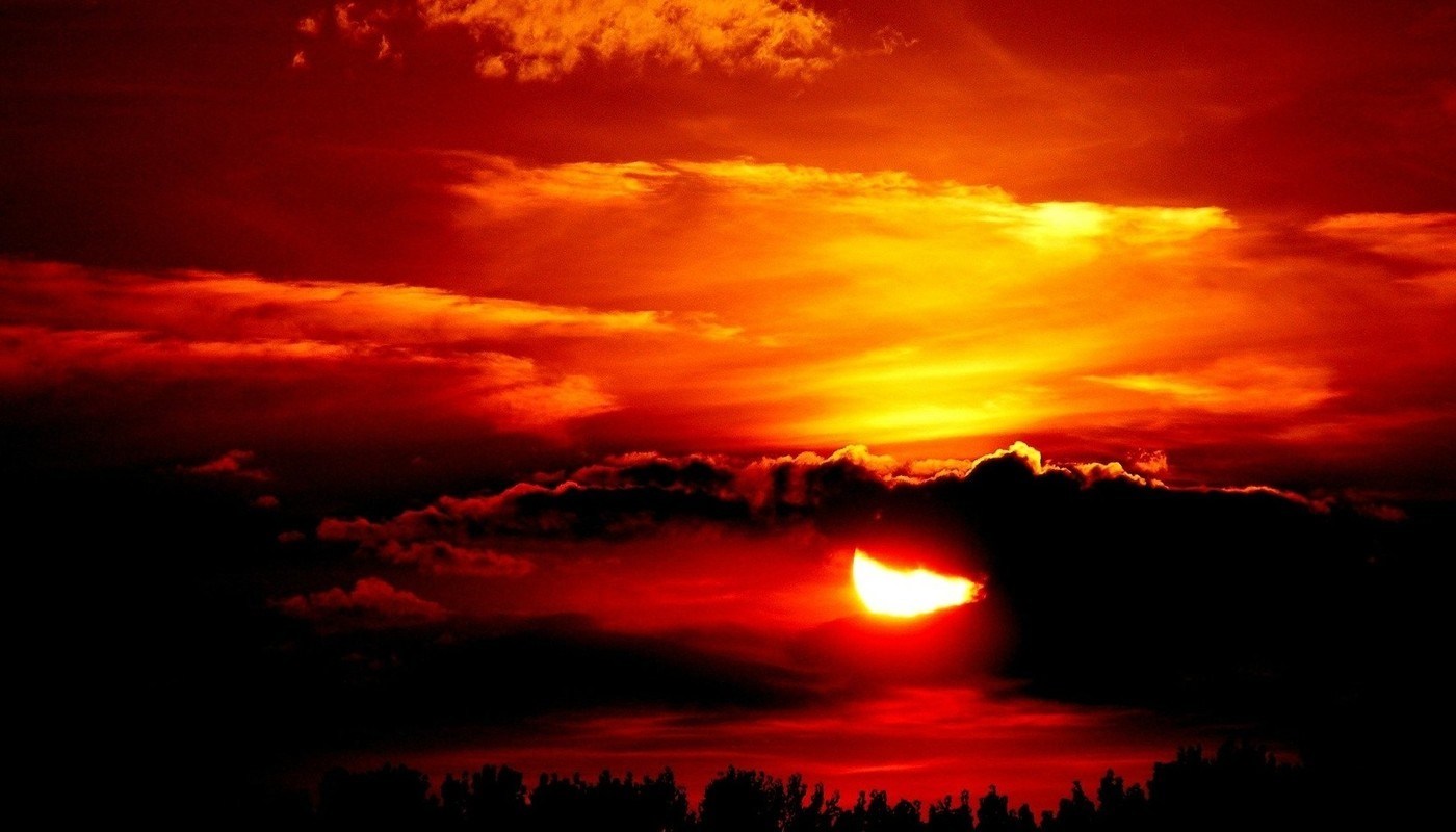 sun behind cloud at sunset