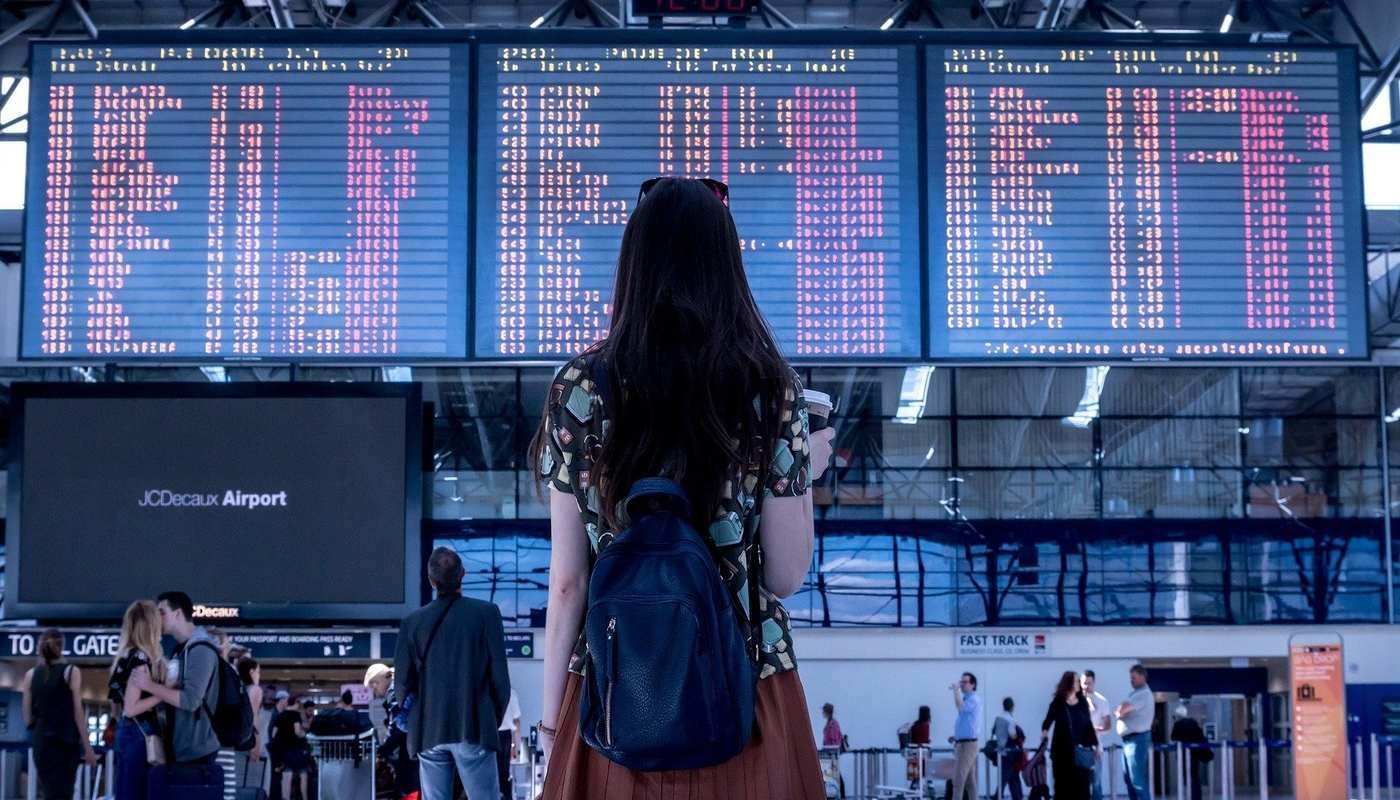 girl looking at destination board in airport